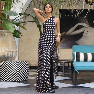 Dettaglio dell'abito lungo in chiffon nero a pois dorati con schiena scoperta e scollo all'americana