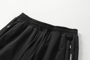 Detail von elastischem Bund mit Kordelzug und Reißverschlusstasche an schwarzer Jogginghose