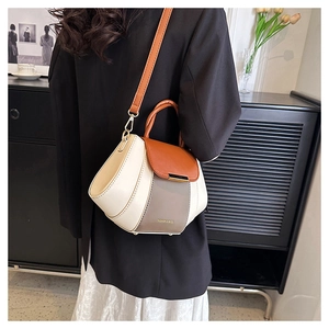 Detail view of a color-blocked PU leather crossbody bag with FASHION & BAGS logo print