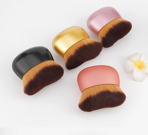 Flat lay of four multi-purpose foundation brushes with dense bristles and metallic handles