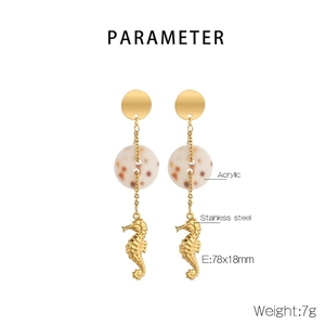 Detail of seahorse earrings with gold stainless steel finish and acrylic marble ring