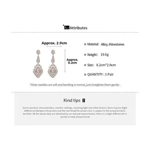 Détail montrant les dimensions des boucles d'oreilles fleurs en strass blancs