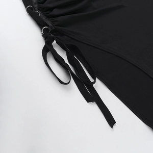 Detailed close-up of the black dress with silver metal rings and tie-up strap design