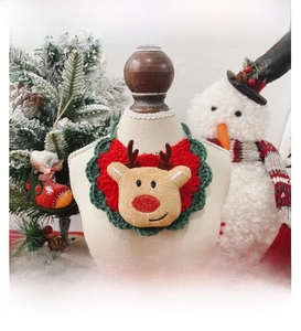 Detail of handmade Christmas pet bib with plush reindeer and festive holiday decorations