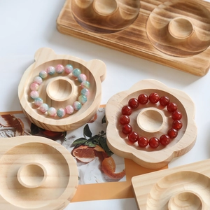 Detail of wooden jewelry tray set with bear and flower shapes and natural wood grain