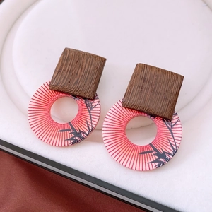Detailed view of vintage wood and red resin earrings with a traditional bamboo pattern