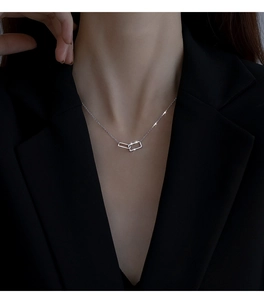 Dettaglio dei ciondoli geometrici in argento intrecciati con diamanti su catena sottile