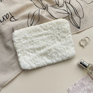 Dettaglio ravvicinato della texture floreale in chiffon 3D e della zip della trousse