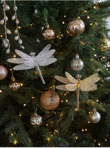 Dettaglio di pendenti a forma di libellula e palline glitterate su un albero di Natale