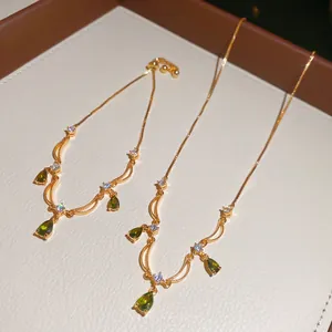 Elegante set collana placcata oro con zircone a goccia verde e accenti in cristallo bianco