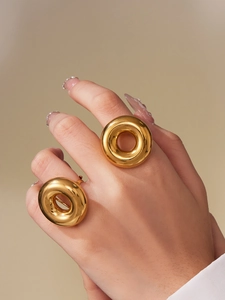 Macro shot of a chunky hollow donut ring in polished 18k gold plated stainless steel