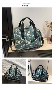 Detail of green travel bag featuring white skulls and roses pattern with sturdy straps