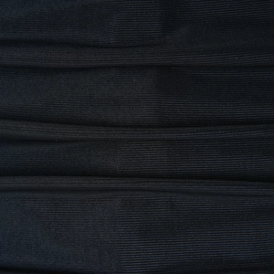 Vista macro della trama del tessuto nero e delle pieghe di un abito aderente alla moda