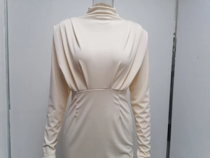 Detailed view of the pleated turtleneck and shoulder draping on this cream slim-fit dress