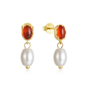 Detailed macro of gold S925 silver earring with red oval gemstone and white pearl drop