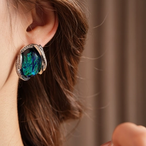 Macro shot of vintage silver earrings with large oval turquoise resin and crystal details