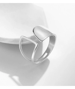 Macro shot of silver open ring featuring irregular geometric cutout and polished finish