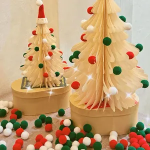 3D paper Christmas tree ornaments with colorful pom-poms on kraft paper box bases