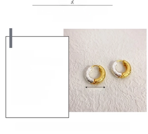 Macro detail of two-tone gold and silver earrings with 18k plating and hammered texture