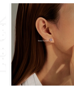 Detail view of 6mm pink round-cut sterling silver stud earring on model earlobe