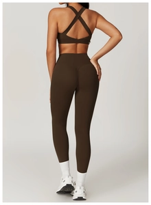 Dettaglio del reggiseno sportivo incrociato e leggings a vita alta caffè scuro
