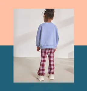 Detail of British style red and white checkered trousers with delicate ruffled edges for girls
