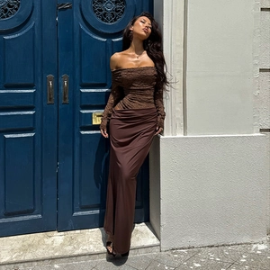 Dettaglio del top in pizzo marrone con spalle scoperte e gonna lunga attillata su modella