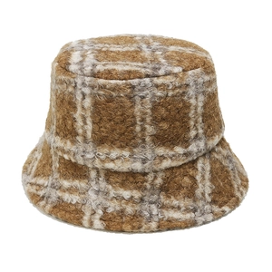 Close-up detail of warm teddy fleece material and brown plaid pattern on bucket hat