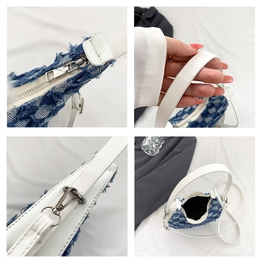 Detail view of denim tweed crescent bag showing white leather strap and silver zipper closure