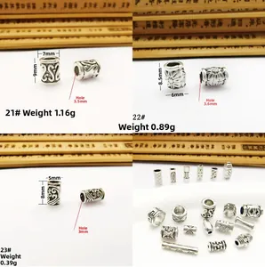 Detailed view of vintage silver hollow spacer beads with intricate floral engravings