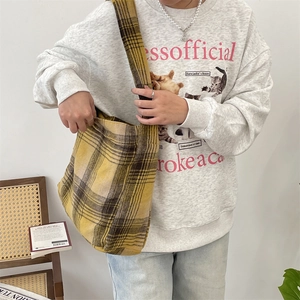 Detail view of large plaid wool tote bag with wide shoulder strap in yellow and brown