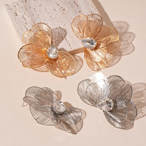 Exaggerated metal flower earrings with rhinestone centers in gold and silver tones