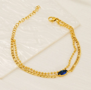 Detailed shot of gold double-layer chain bracelet featuring a blue marquise zircon stone
