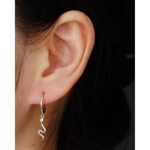 Detail of S925 sterling silver snake-shaped hoop earring with shimmering zircon accents