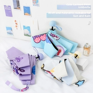 Detailed view of three pastel folding umbrellas with cute cartoon motifs and round handles