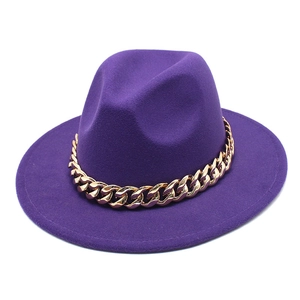 Detail view of purple fedora hat featuring a bold gold metal chain on wool felt brim