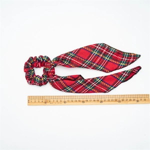 Red plaid velvet scrunchie with long ribbon streamer and size reference on white background