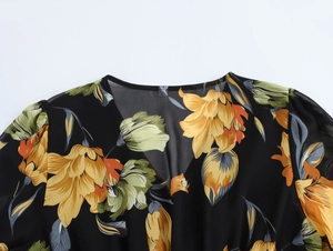 Dettaglio dello scollo a V e della spalla di un abito in chiffon floreale giallo e verde