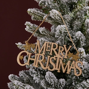 Stella di Natale in legno con glitter dorati appesa a un ramo di pino innevato per decoro