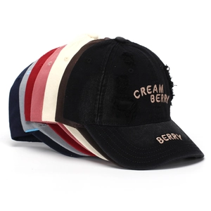 Detail of stacked vintage baseball caps with Cream Berry embroidery and distressed edges