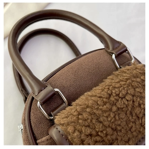 Detail of plush brown tote with lamb wool trim and silver buckle hardware