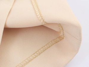 Detailed macro view of beige elastic knitted fabric with premium stitching craftsmanship