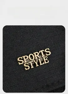 Macro shot of sports style golden metal logo on high-quality black fabric cap texture