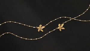 Detailed close-up of 18K gold-plated floral pendant necklace with white pearl beads