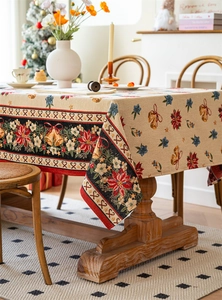 Macro detail of Christmas tablecloth featuring poinsettia and holly jacquard patterns