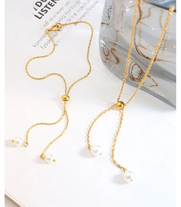 Detail of gold pearl jewelry set featuring adjustable slide beads on delicate chains