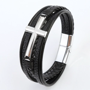 Close-up of multilayer black leather braided bracelet with a silver metal cross and magnetic clasp