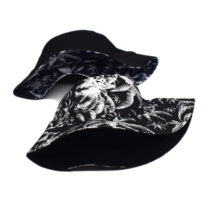 Detailed view of reversible cotton bucket hats with black and palm tree print patterns