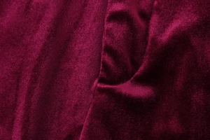 Macro detail of luxurious burgundy velvet fabric showing smooth texture and soft luster
