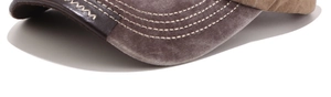 Detail of washed canvas baseball cap brim with leather edge and contrast stitching